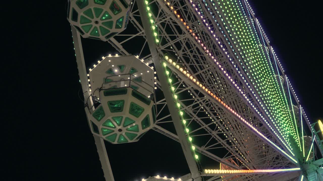 vista nocturna de la rueda de la ferris. luces brillantes de varios colores.