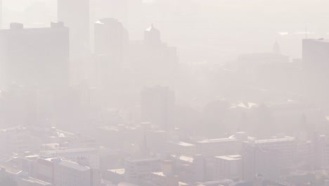 general view of cityscape with multiple tall skyscrapers and buildings covered in fog