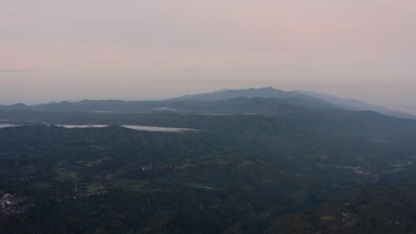 Misty-pink-aerial-drone-view-over-landscape-at-early-morning-sunrise