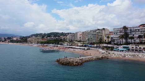 Drone-shot-people-relaxing-on-sand-beach-on-coast-in-southern-France