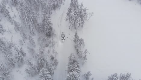 Aerial-View-Of-A-Tractor-Driving-On-A-Snow-Blanket-Nature