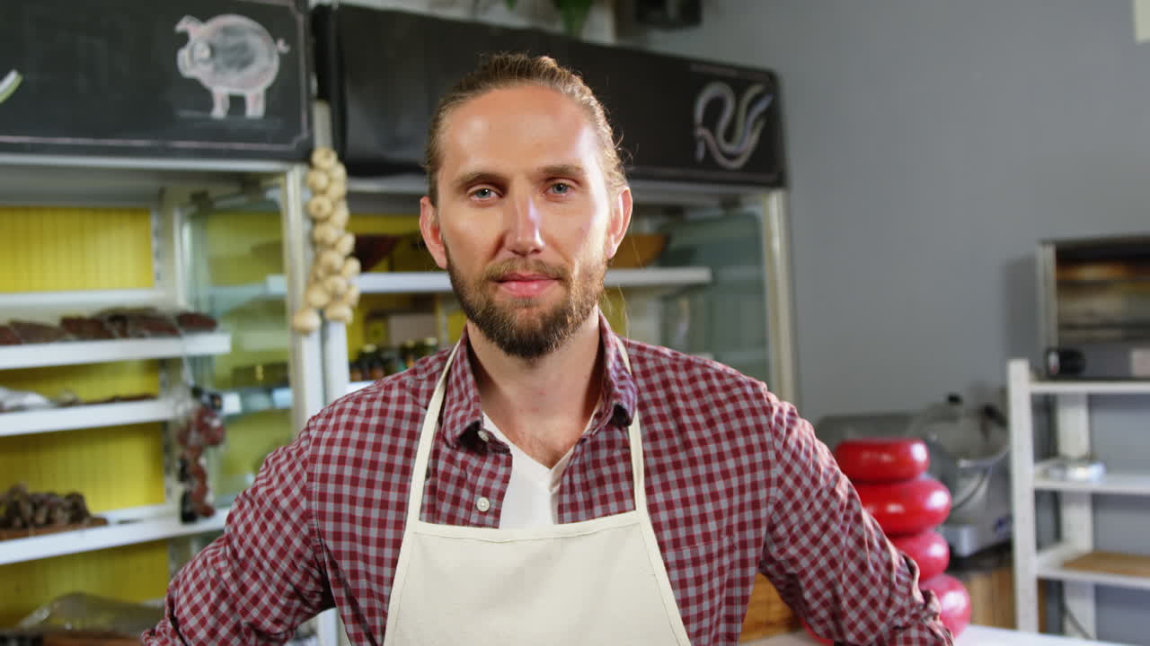 personal masculino sonriente de pie con los brazos cruzados en la sección de panadería