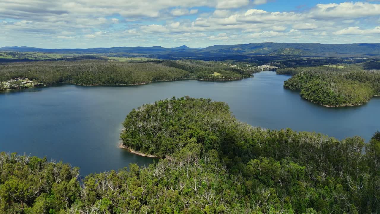 Aerial of Lake Conjola wetlands with winding channels and green vegetation, panoramic midday establishing