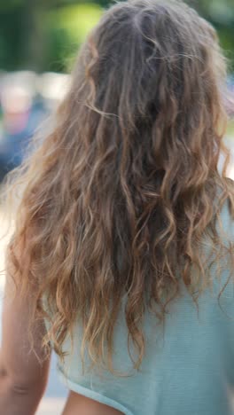 woman with curly hair walking outdoors