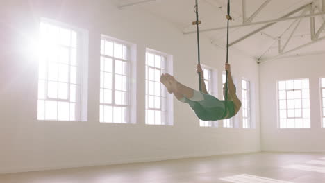 aerial yoga woman practicing hanging upside down using hammock enjoying healthy fitness lifestyle exercising in studio training meditation at sunrise