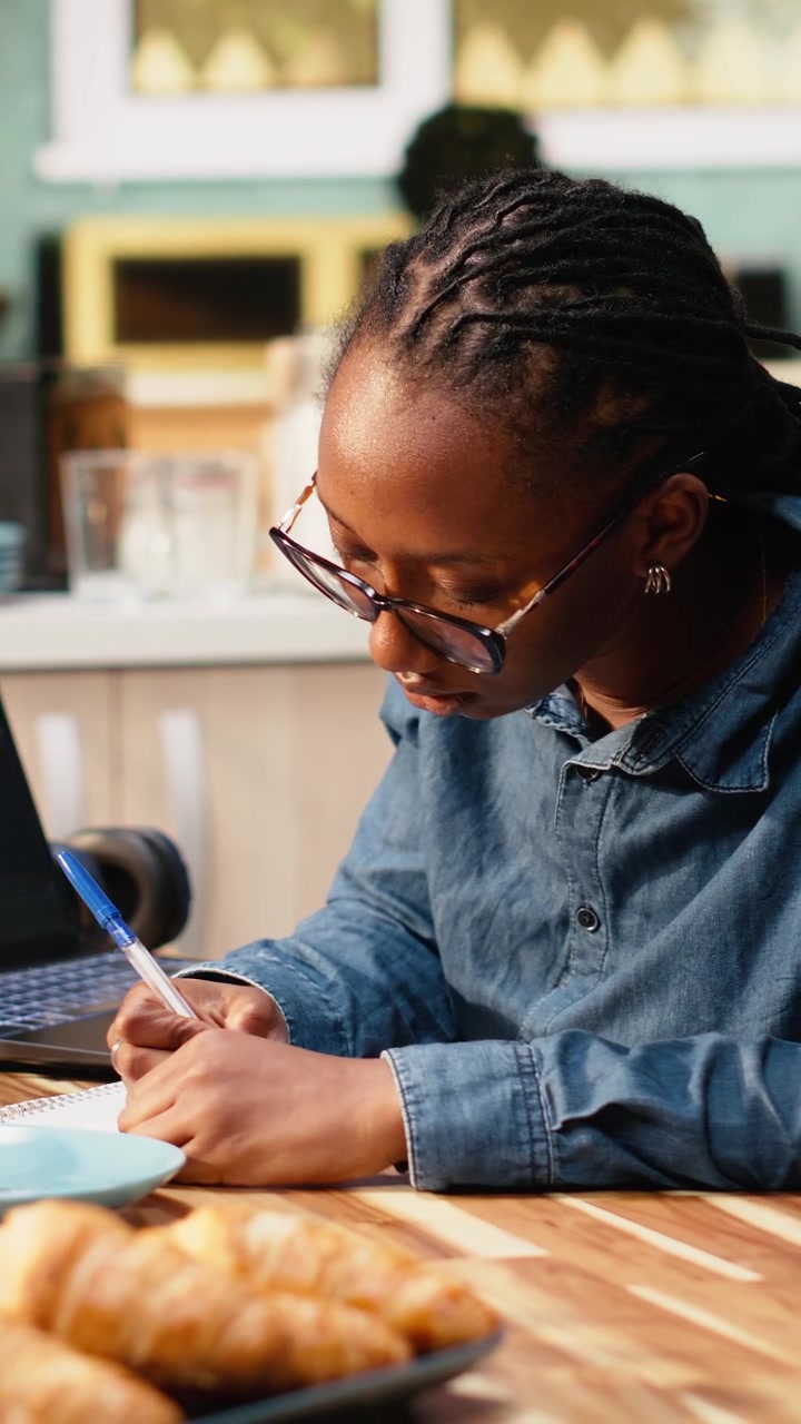 Vertical Video One person coding on laptop in kitchen representing remote work