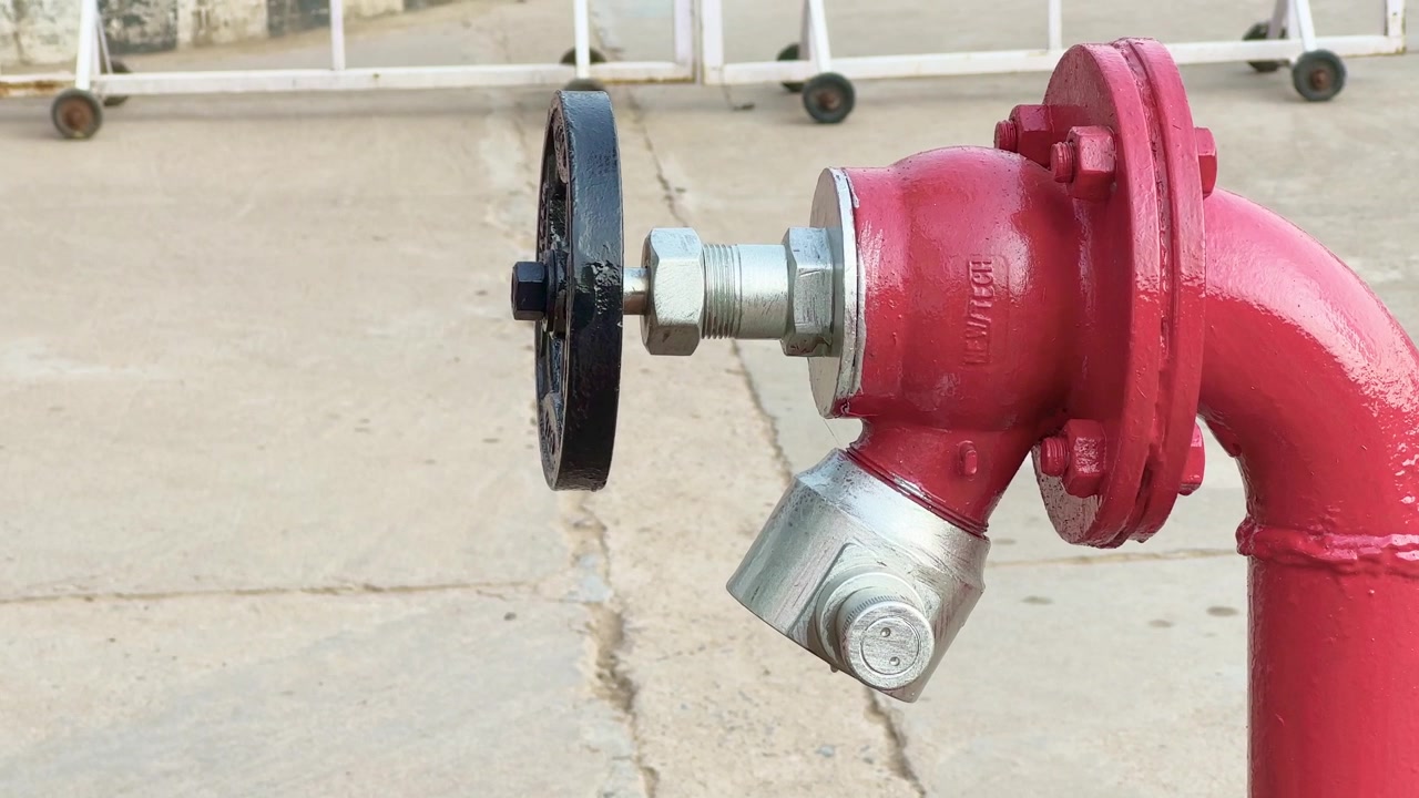 Idrante antincendio rosso a uscita singola per l'estinzione degli incendi, primo piano dei punti di connessione dell'idrante antincendio installati presso la struttura dell'edificio che i vigili del fuoco utilizzano per accedere a una riserva d'acqua
