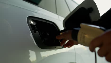 persona que carga un vehículo eléctrico