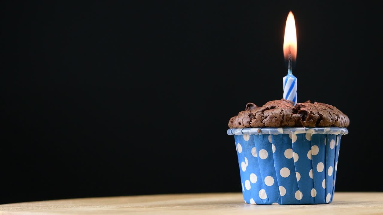 fiesta de pasteles con vela en fondo azul cinemagraph bucle sin costuras.