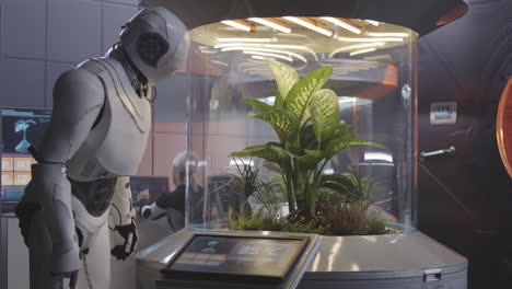 robot tending a plant in a controlled environment