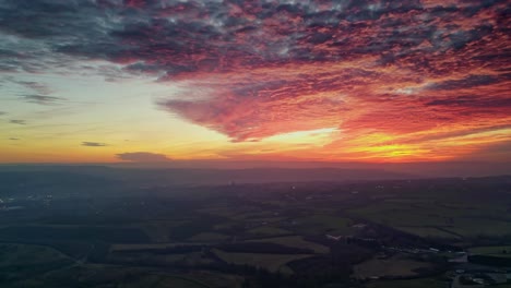 Drohne-Filmische-Landschaft-Landschaft-Grün-Nebligen-Felder-Bunt-Rot-Sonnenuntergang-Horizont-Feurige-Wolken