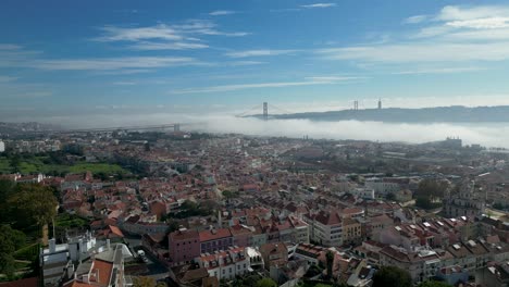 the 25th of april bridge in the city of lisbon covered in morning fog