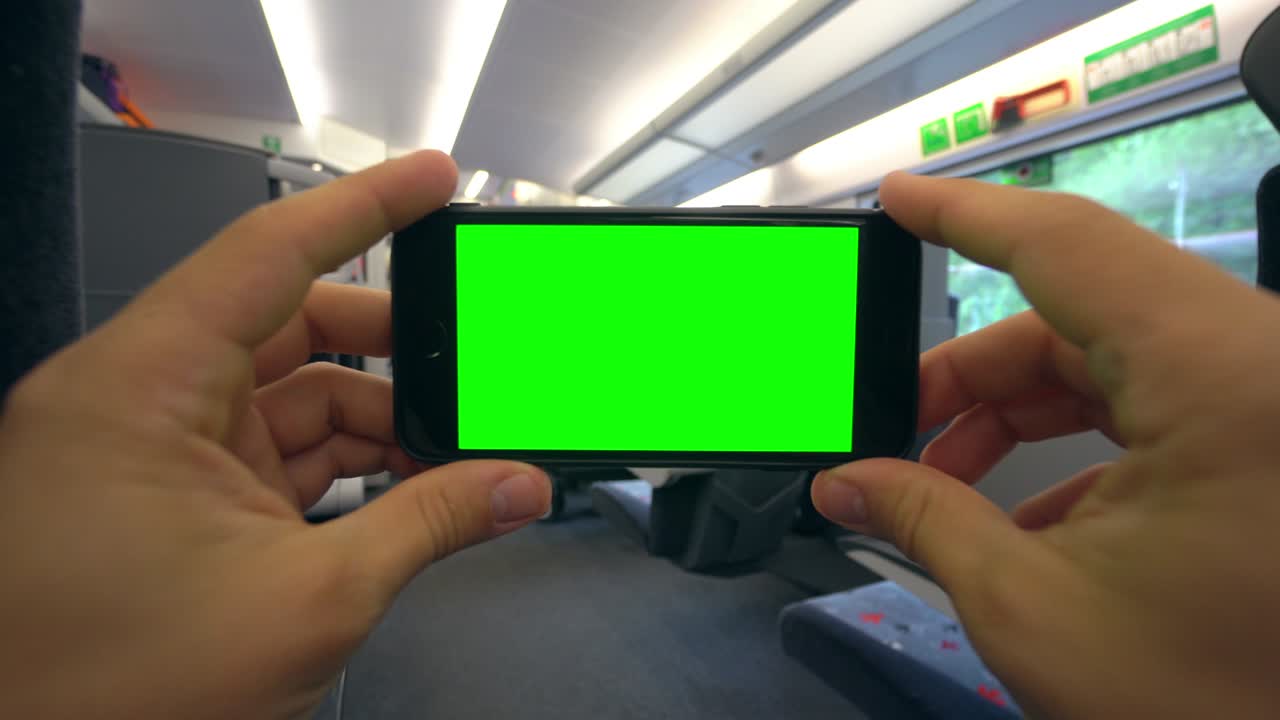 기차에서 초록색 화면으로 전화를 들고 있는 손