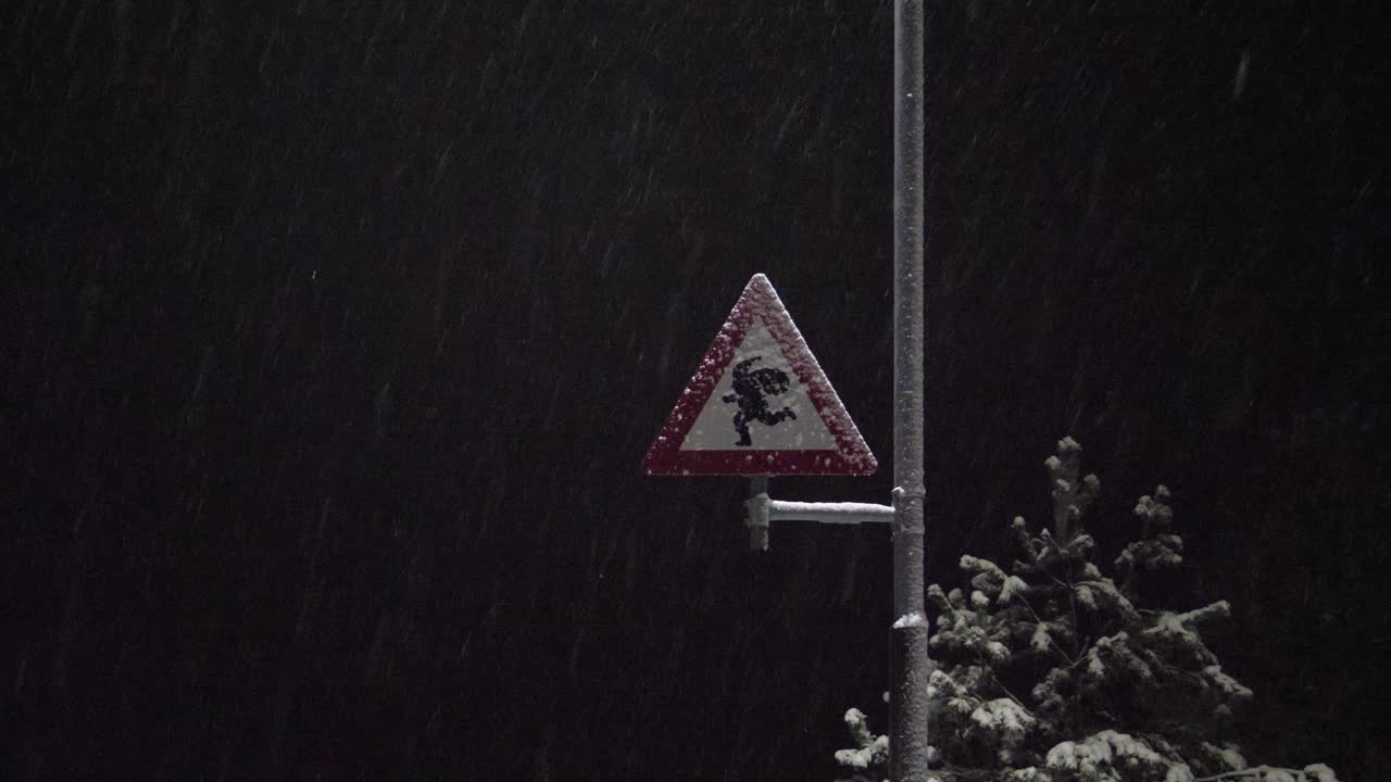 Street sign at the North pole warning drivers to be careful of Santa or Elves crossing the street - snowy night static