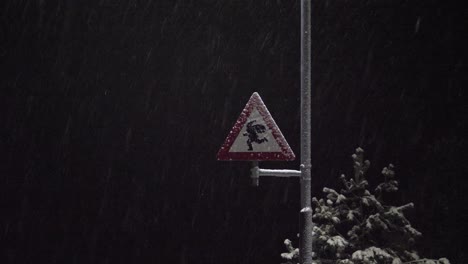 street sign at the north pole warning drivers to be careful of santa or elves crossing the street - snowy night static
