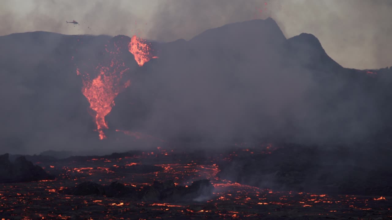 helicóptero volando sobre la erupción piscina de lava humo islandia