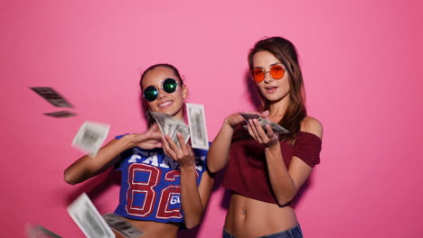 two women throwing money in the air