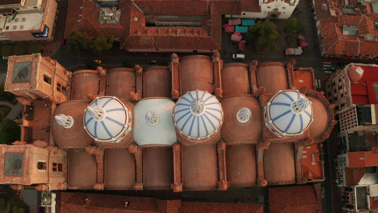 Stunning aerial drone shot of the historic center of Cuenca, Ecuador, highlighting the iconic blue domes of the Cathedral of the Immaculate Conception.