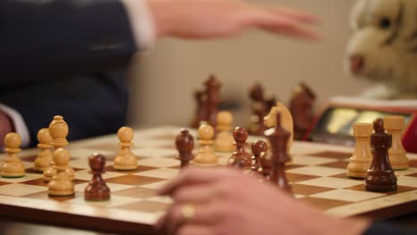 Closeup-of-a-chessboard-while-businessmen-playing-speed-chess-on-it