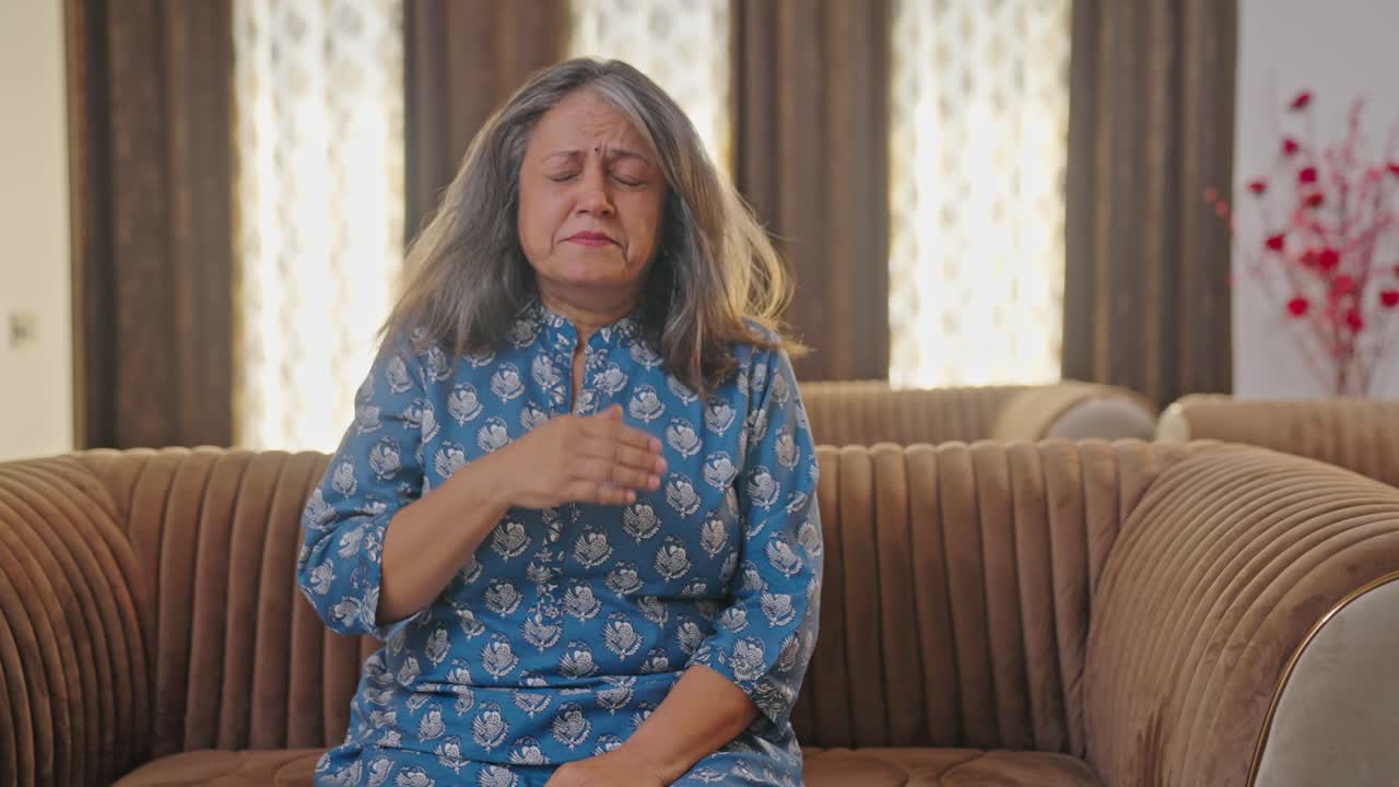 Anziana donna indiana che soffre di raffreddore e tosse