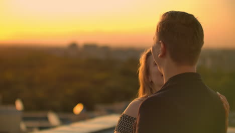 due amanti ballano insieme sul tetto al tramonto alla luce del sole. danza romantica