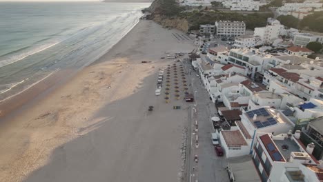 el sol poniente dibuja largas sombras en la arena de la playa de salema en la región portuguesa del algarve