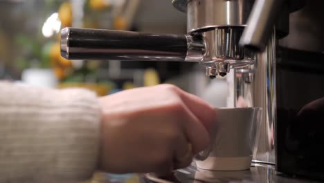 colocando la taza de café en su lugar, para ser llenada