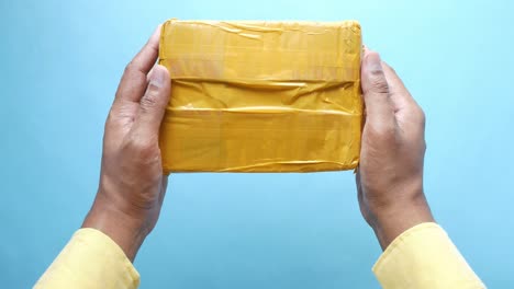 hands holding a yellow package