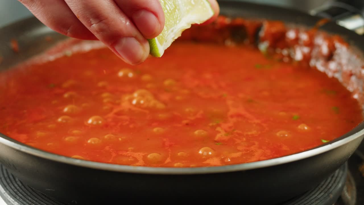 Boiling tomato sauce on a frying pan close-up. Cooking tomato sauce or soup. Traditional Italian Mexican Asian dish. High quality studio shot for cafe, restaurant close up. Marinara sauce for Italian pasta