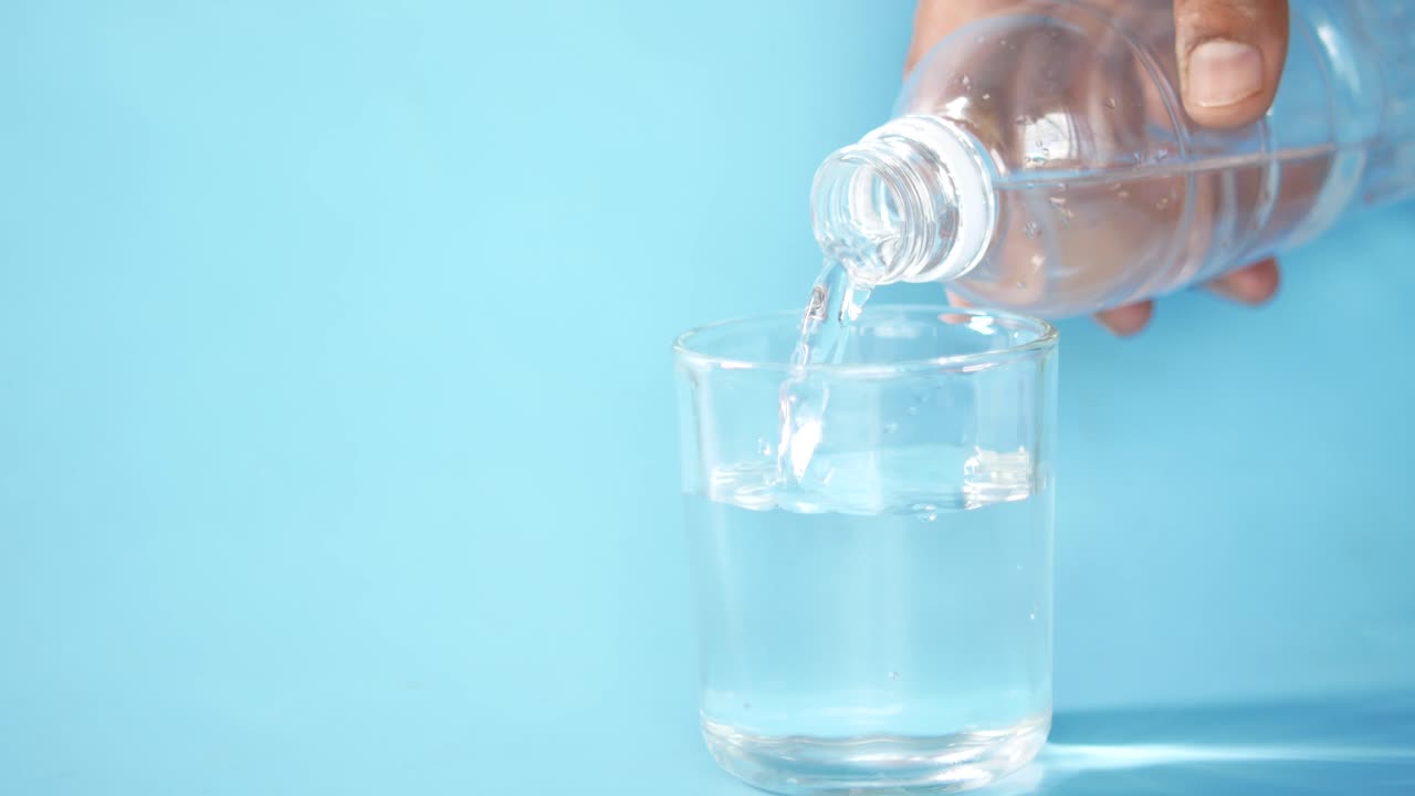verter agua de la botella en el vaso