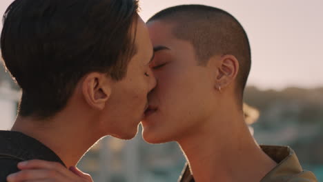 young homosexual couple kissing enjoying rooftop party at sunset dancing together sharing intimate connection group of friends having fun celebrating summer vacation