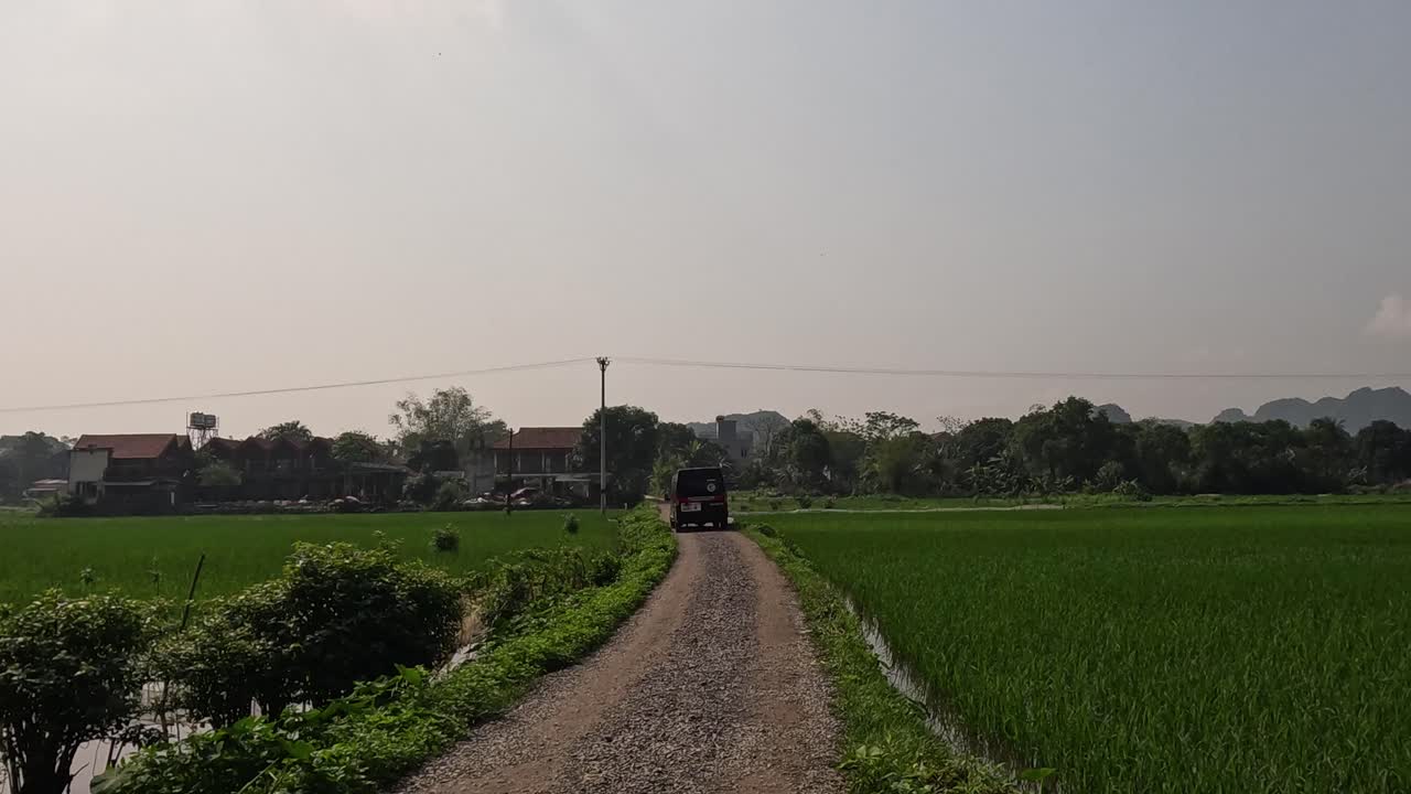 자동차가 초록색 을 가로질러 길을 내려가고 있다.