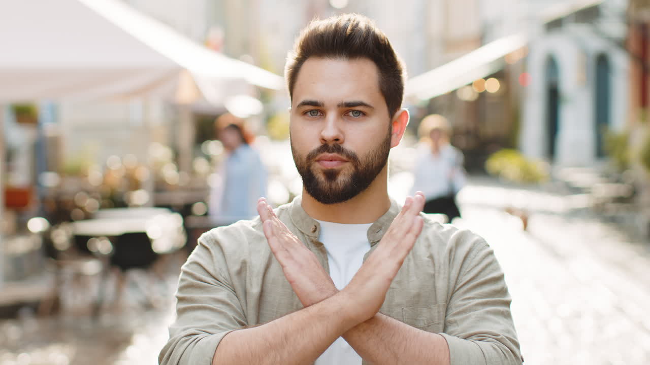 Displeased upset young adult man reacting to unpleasant awful idea wave hand finger shake head no