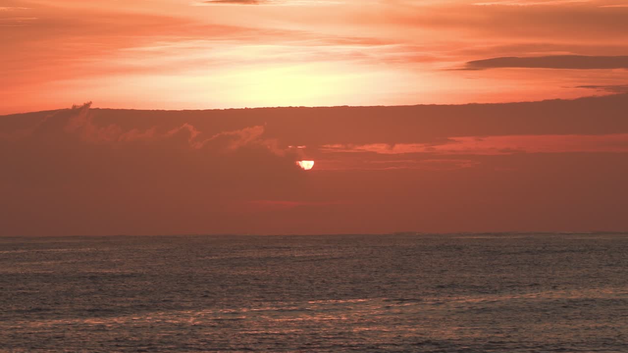 석양의 잔잔한 바다, 아름다운 구름과 함께 낮은 주황색 하늘에 태양