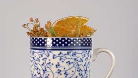 flor de tilo turco y rodajas de naranja en taza