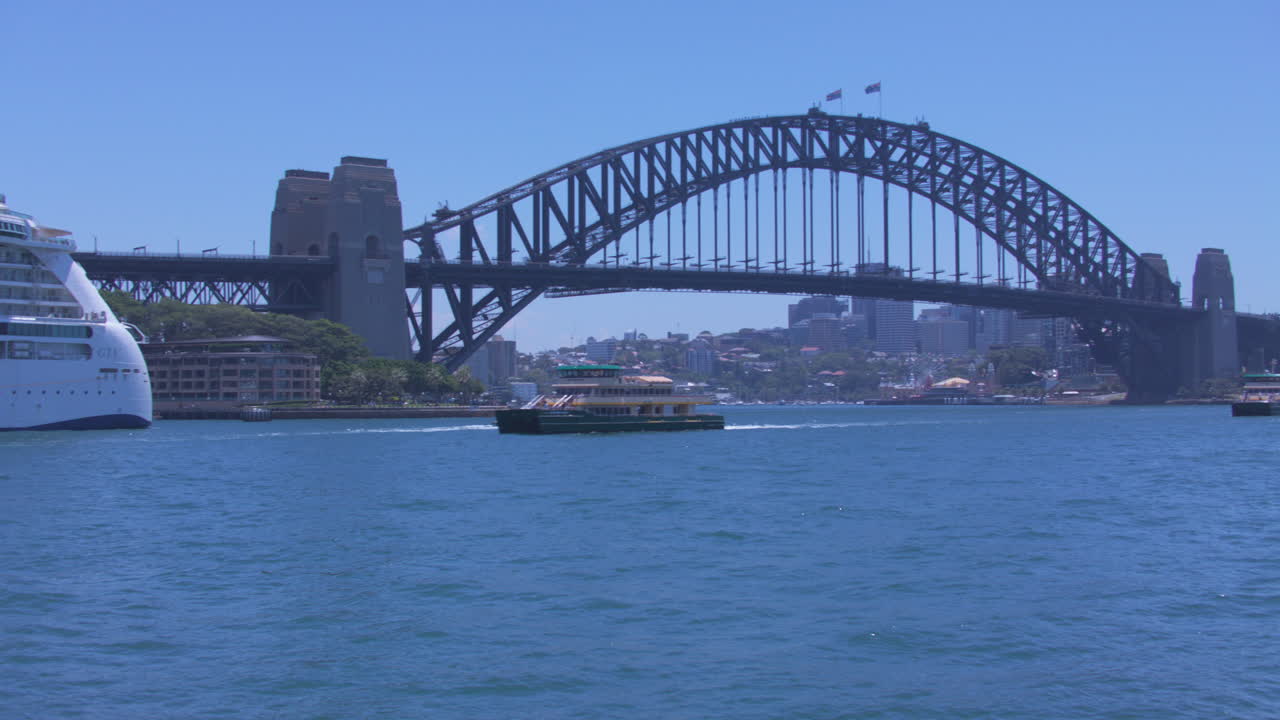 시드니 의 페리 가 시드니 오스트레일리아 의 하버 브릿지 를 배경 으로 한 밝은 빛 날 에 서클러 케이 에 도크 에 들어간다