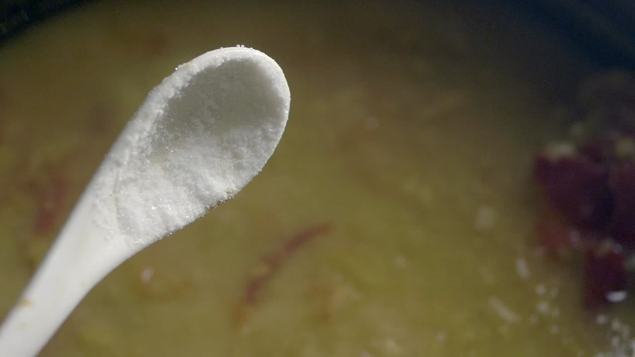Adding White Powder from a Spoon into a Cooking Dish