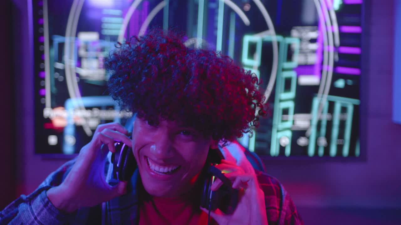 A young biracial man talks on his gaming headset at home, copy space