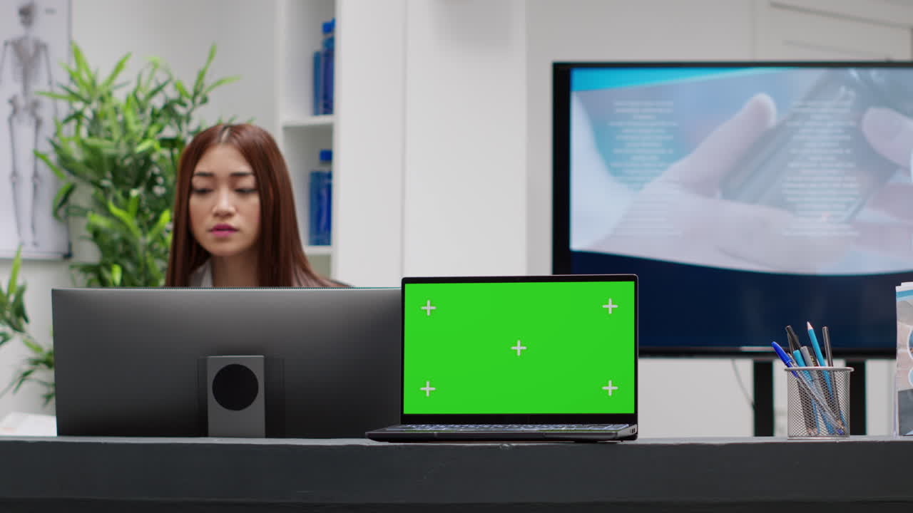 Reception ospedaliera con computer con green screen e staff medico