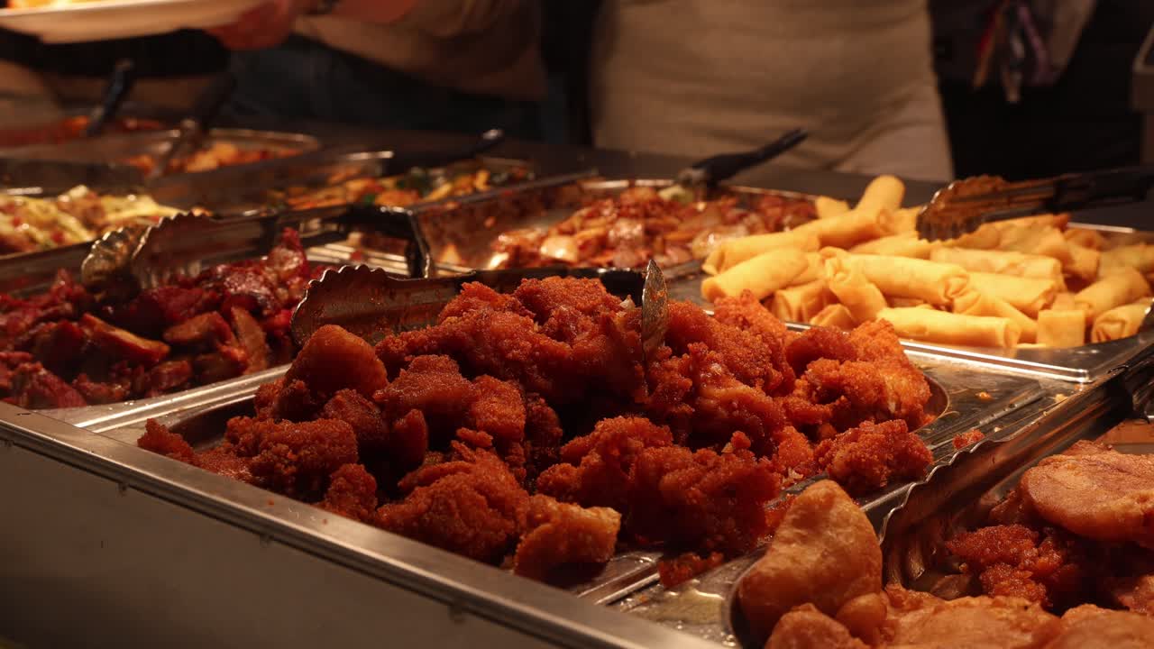 Primo piano di un buffet cinese, persone che prendono il cibo dal tavolo