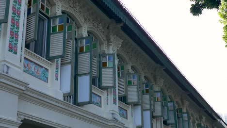 Slow-motion-landscape-view-of-colourful-window-panes-shutters-shades-on-apartment-block-housing-balcony-Singapore-design-art-Asia-architecture