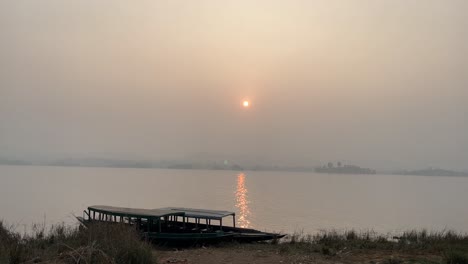 the sun is setting over the lake.