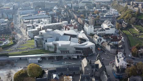 a high drone shot directly above the queen's palace, showing dynamic earth, the holyrood scottish parliament to calton hill