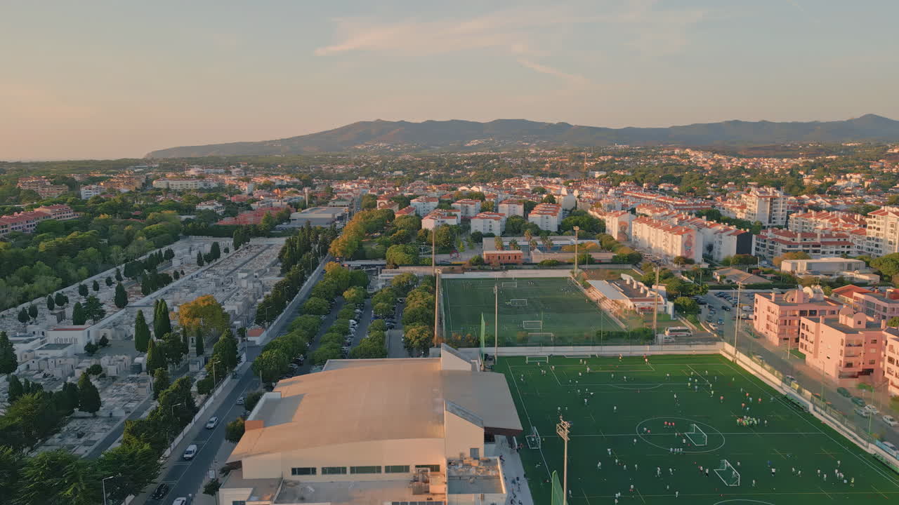 Drone peaceful small town with  green football stadium. Urban districts