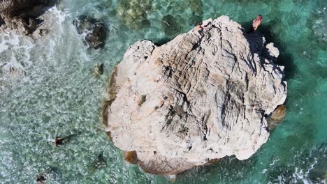 Overhead-aerial-view-of-rock-over-the-ocean-water