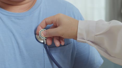 close up of a male doctor's hand using stethoscope with a patient for medical check up in clinic