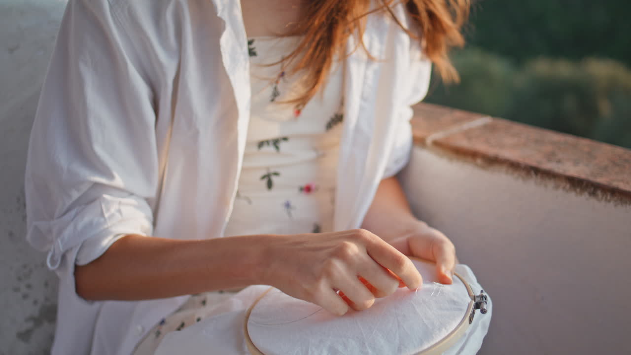 발코니에서 손으로 바늘을 는 여자 클로즈업. 여자 교차 매