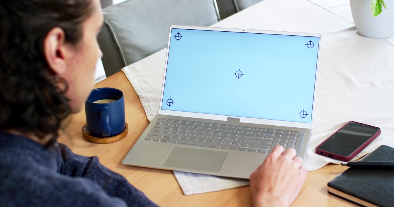 African American man sitting left at table adjusting hand on laptop seeing blue markers, copy space