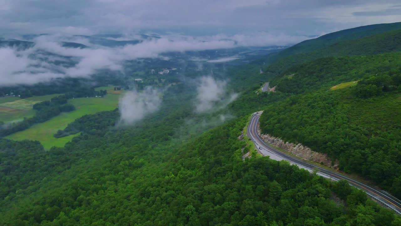 Aerial drone time lapse video footage of clouds on a scenic highway in the Appalachian Mountains during summer. This is in New York's Hudson Valley on Shawangunk Ridge.