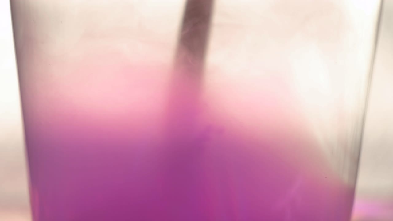 фиолетовая жидкость смешивается в стакане